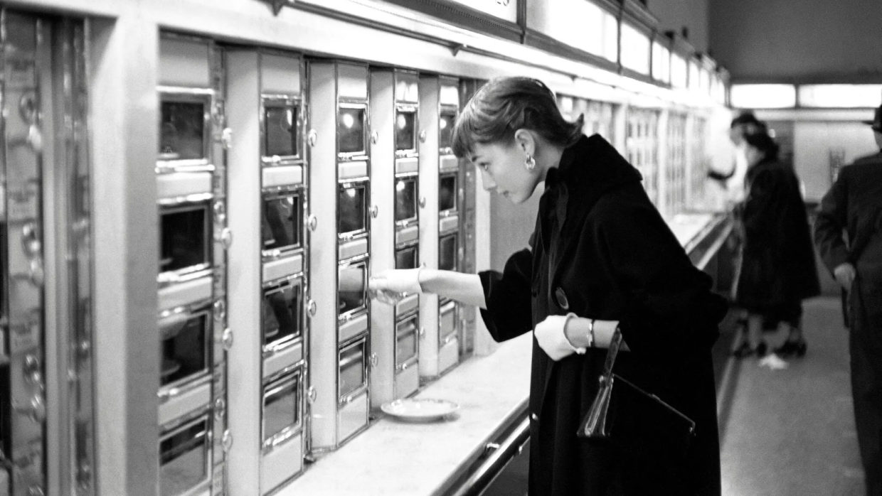 The actress Audrey Hepburn ordering food from an automat