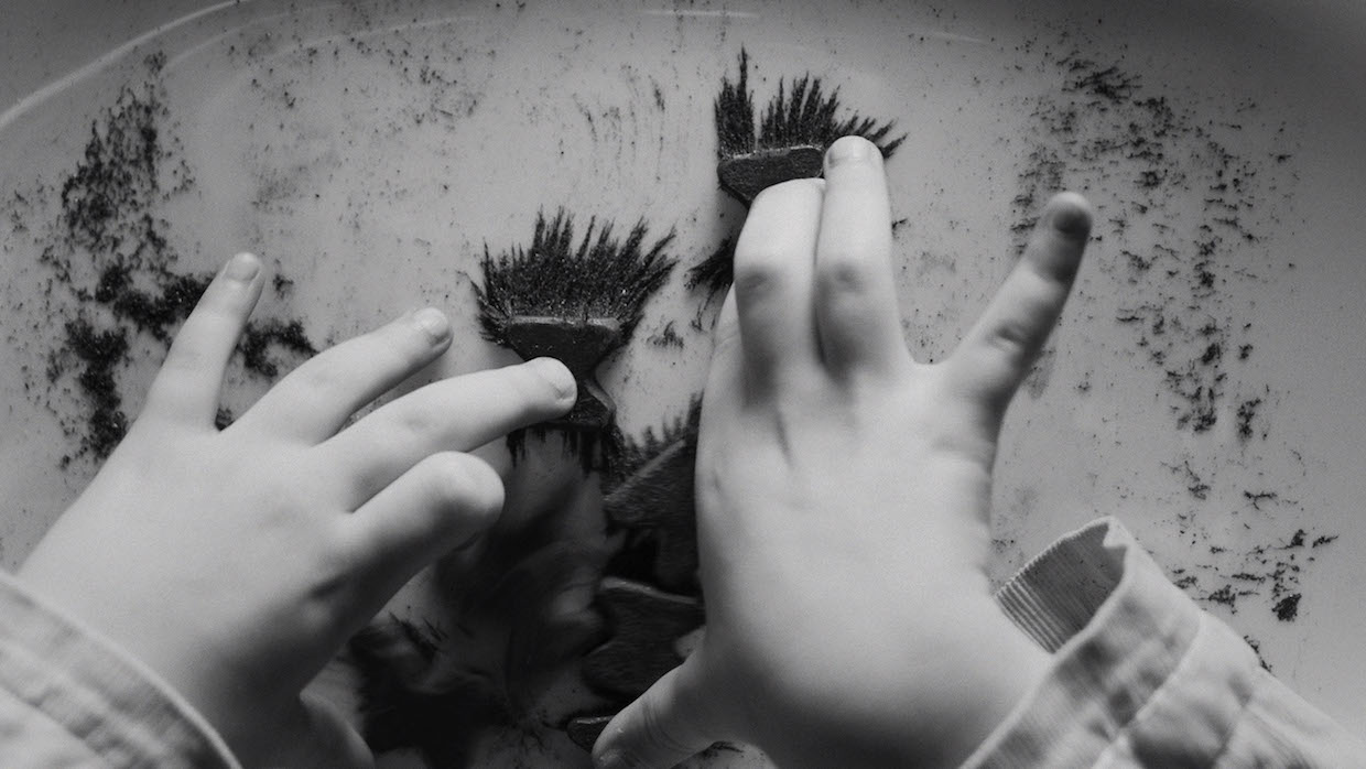 A child's hands are shot in a black and white photograph.