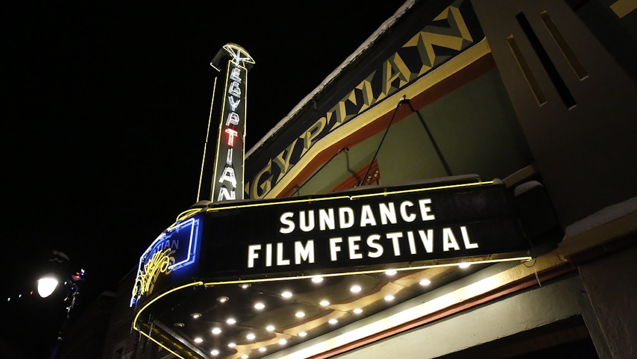 Park City, Utah's Egyptian Theater lit-up at night, the marquee reads "Sundance Film Festival"