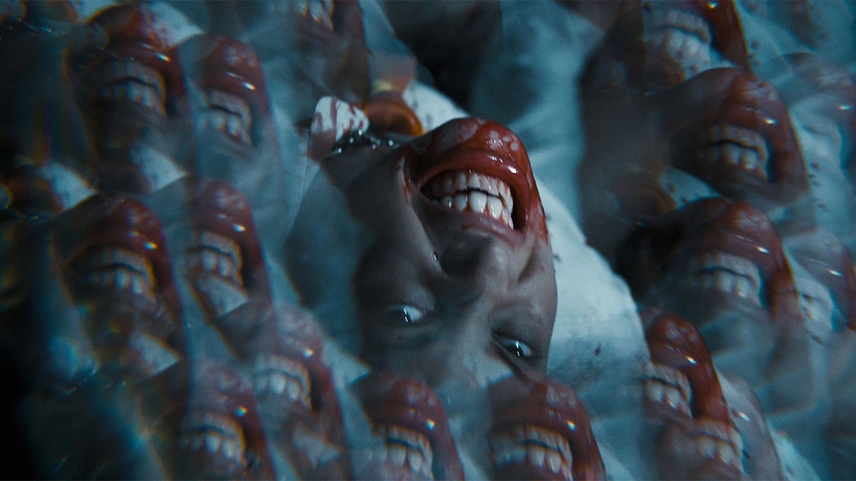 A kaleidoscopic image of a girl's face, her teeth are bared and her mouth is covered in blood.