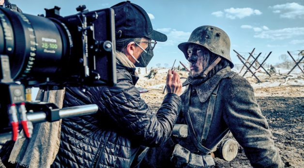 Actor Felix Kammerer as Paul Bäumer in All Quiet on the Western Front. He wears a WWI-era military uniform and has his face painted with soot behind the scenes.
