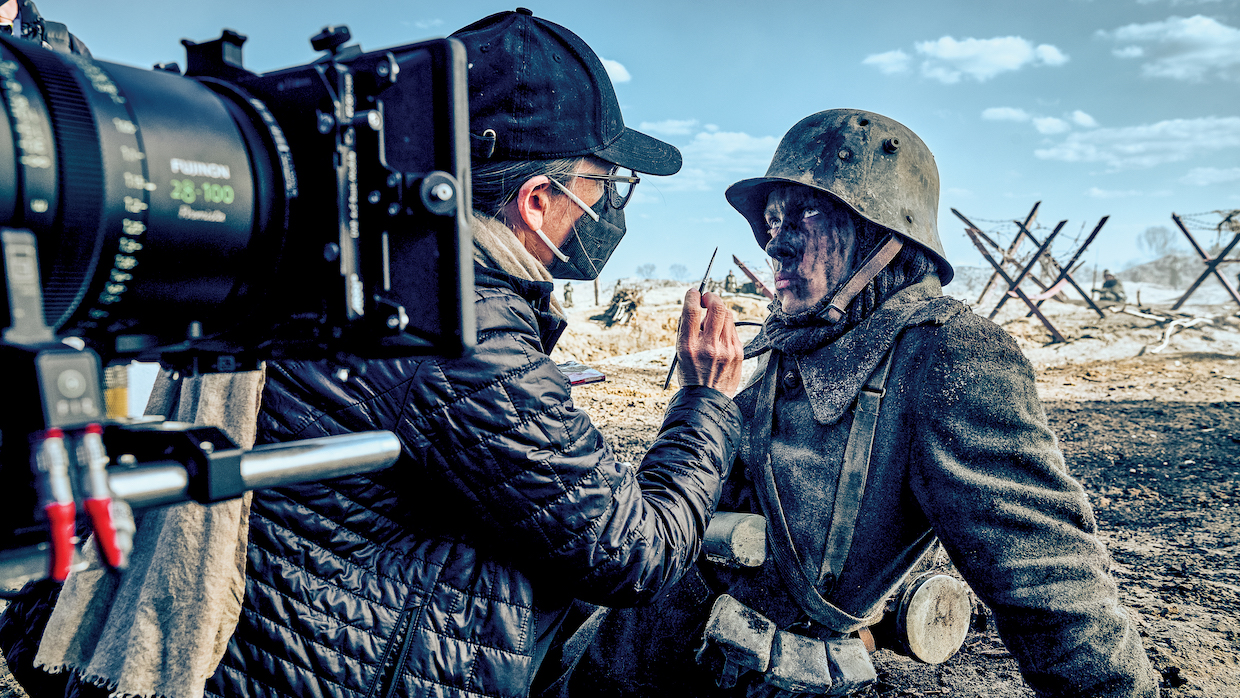 Actor Felix Kammerer as Paul Bäumer in All Quiet on the Western Front. He wears a WWI-era military uniform and has his face painted with soot behind the scenes.