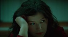 Singer-songwriter Lucy Dacus rests her head on her palm and looks to the side.