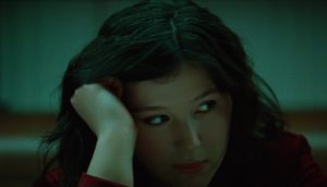 Singer-songwriter Lucy Dacus rests her head on her palm and looks to the side.