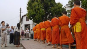 A tourist photographs monks in Laos in Kimi Takesue's Onlookers