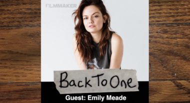 Actress Emily Meade's headshot. She has long, wavy brown hair and wears a gray tank top.