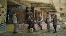 A small film crew records a man in an underpass filled with graffiti.