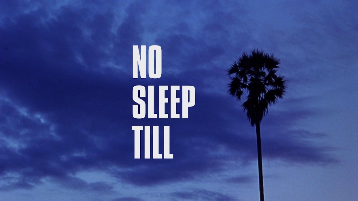 A single palm tree is captured amid a stormy, purple sky. Text to the left of the palm tree reveals a title card: No Sleep Till.