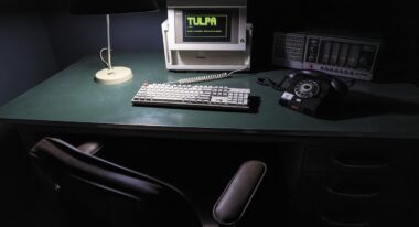 An old desktop computer with the word "Tulpa" on the monitor rests on a green table.