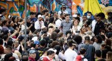 A large group of people listen and film at a Francia Márquez rally in Colombia.