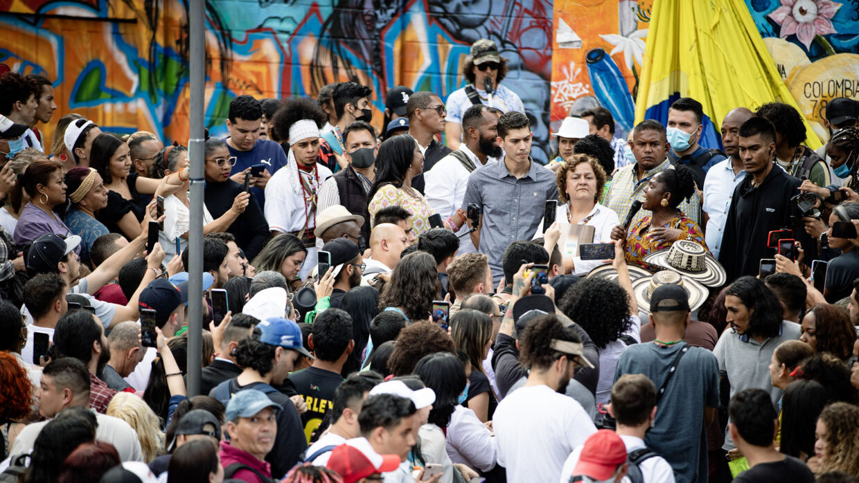 A large group of people listen and film at a Francia Márquez rally in Colombia.