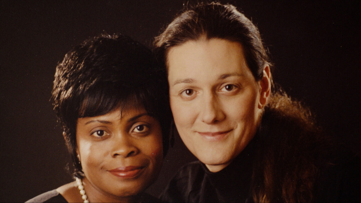 A portrait photo of a middle-aged couple, a white woman and an African-American woman.