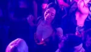 A young woman dances in a club.