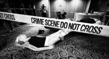 A mannequin simulating a corpse lies on the floor of a cruise ship made up to resemble a crime scene.