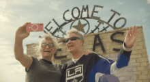 Two people take a selfie outside a Texas tourist spot.