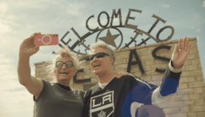 Two people take a selfie outside a Texas tourist spot.