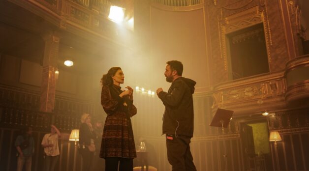 A director discusses a scene with an actress while on stage.