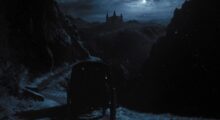 A carriage drives towards a gloomy castle on a moonlit night.