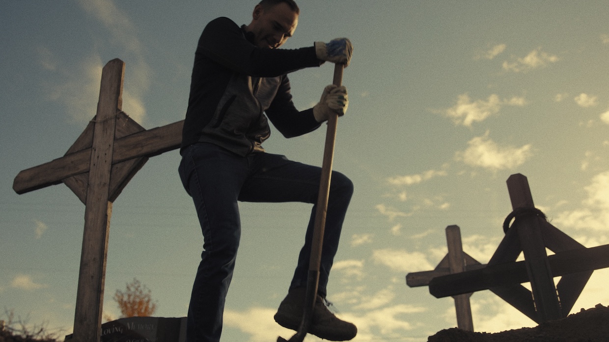 A man digs in a graveyard.