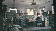 Countless stacks of books are piled up in a room.