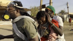 Three Sudanese wearing masks are in the streets.