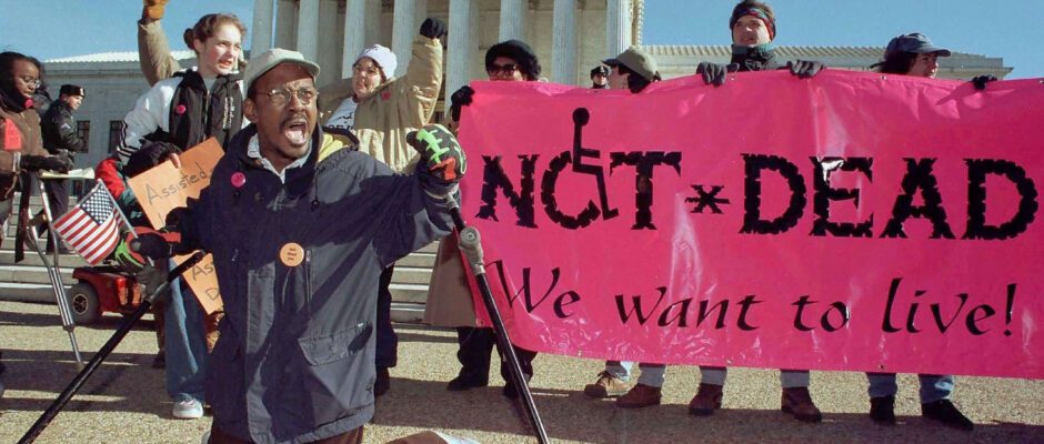 A disabilities rights protest with a banner reading "Not Dead, We Want To Live" visible.