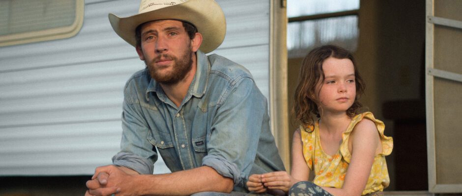 A white man and a young white girl sit outside a home.