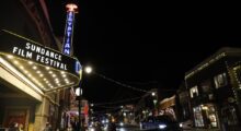 A marquee of a movie theater illuminated at night.