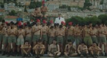 Dressed in anachronistic Italian uniforms, a group of young men stare at their smartphones.