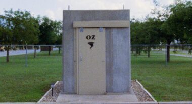 A concrete block of a shelter rests in a field.
