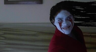 A pale humanoid leans to the side, grinning widely as blood drips from its eyes.