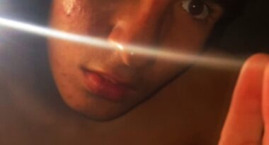 A teenager stares into the bright light of a cellphone.