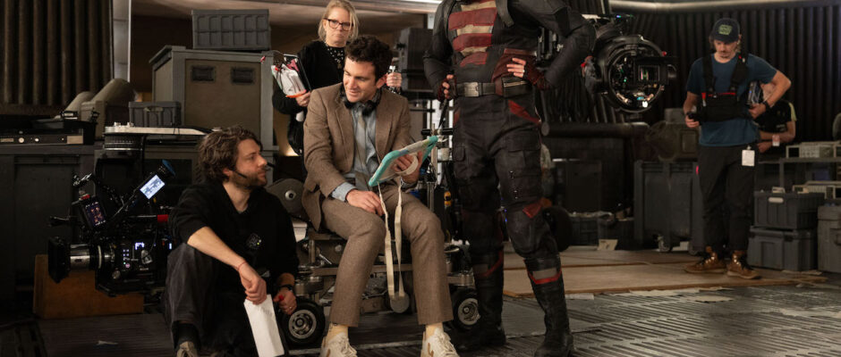 A group of people on a film set, one of whom is in a superhero costume.