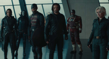 A group of superheroes stand in a lobby.